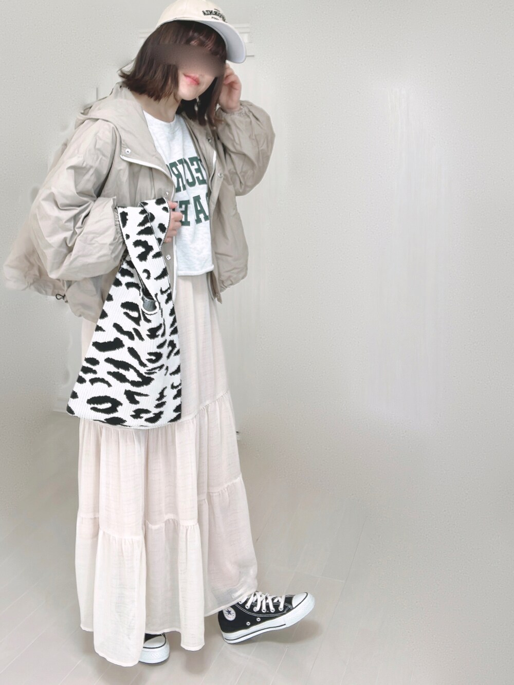 ベージュ系のマウンテンパーカー、ホワイト系のスカート、ブラック系のスニーカーを着用したレディースの春コーディネートの4枚目の写真