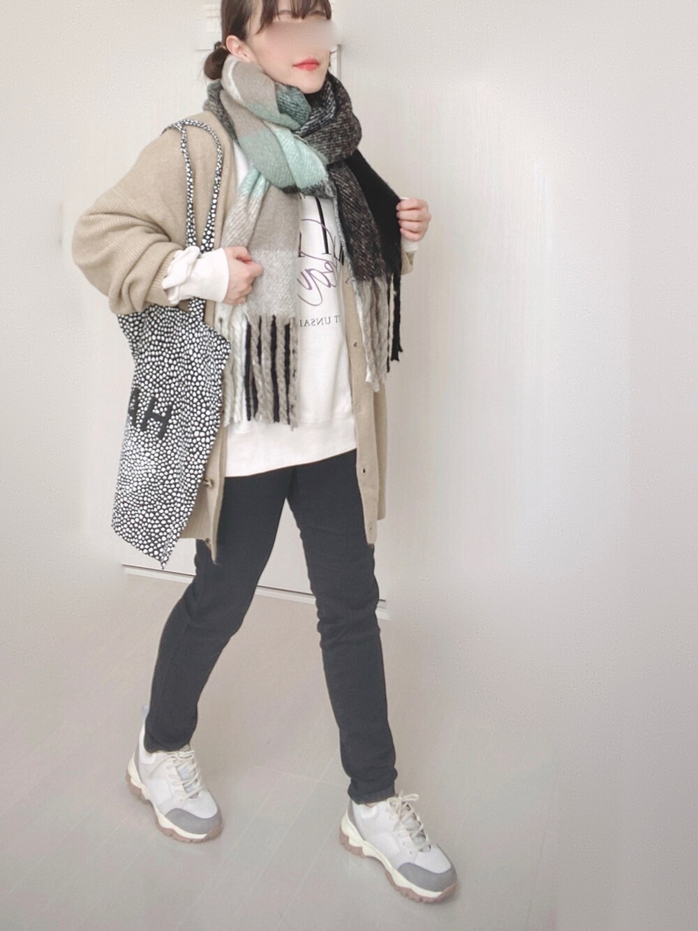 ベージュ系のカーディガン/ボレロ、ブラック系のデニムパンツ、ベージュ系のスニーカーを着用したレディースの冬コーディネートの3枚目の写真