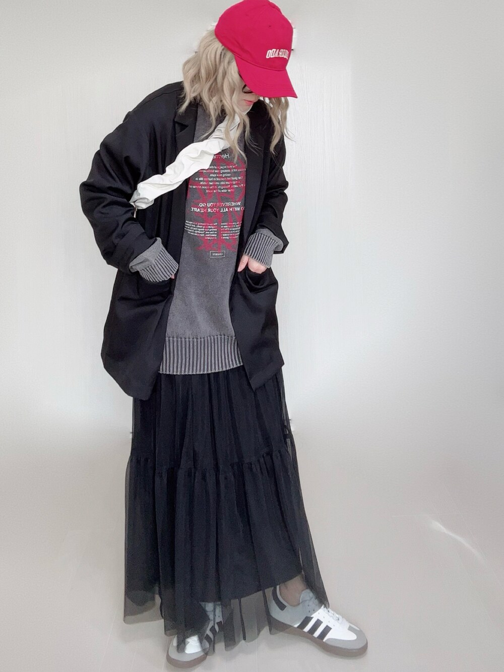 ブラック系のニット/セーター、ブラック系のテーラードジャケット、ブラック系のスカートを着用したレディースの冬コーディネートの3枚目の写真