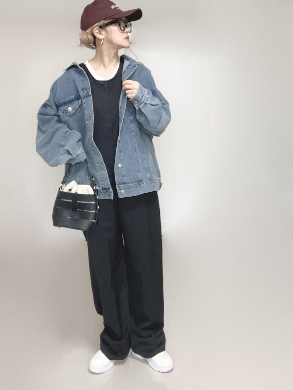 ブルー系のデニムジャケット、ブラック系のつなぎ/オールインワン、ホワイト系のTシャツ/カットソーを着用したレディースの春コーディネートの4枚目の写真