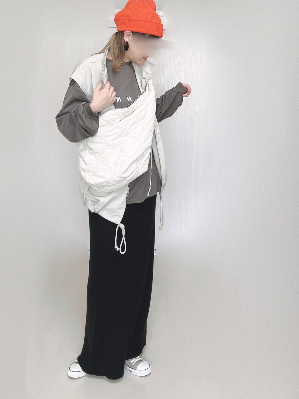 ホワイト系のショルダーバッグ、ホワイト系のベスト、ブラック系のスカートを着用したレディースの秋コーディネートの5枚目の写真