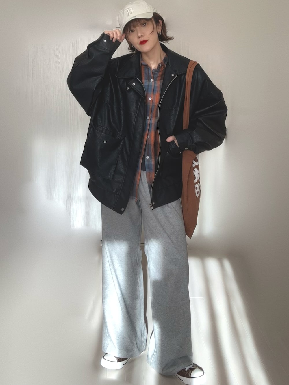 ブラック系のブルゾン、ブラウン系のトートバッグ、ベージュ系のキャップを着用したレディースの冬コーディネートの3枚目の写真