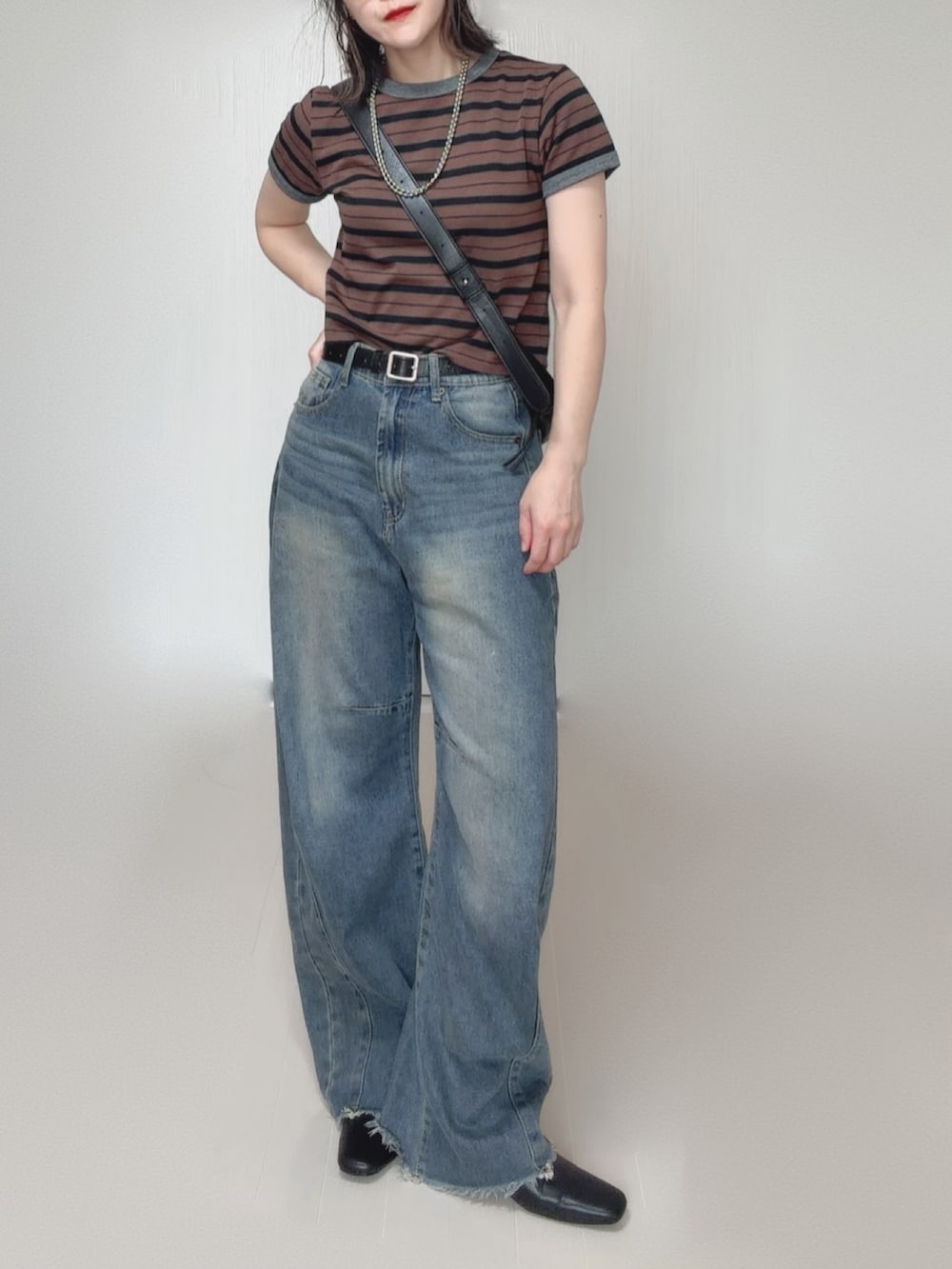 ブルー系のデニムパンツ、ブラウン系のTシャツ/カットソー、ブラック系のスリッポンを着用したレディースの秋コーディネートの5枚目の写真