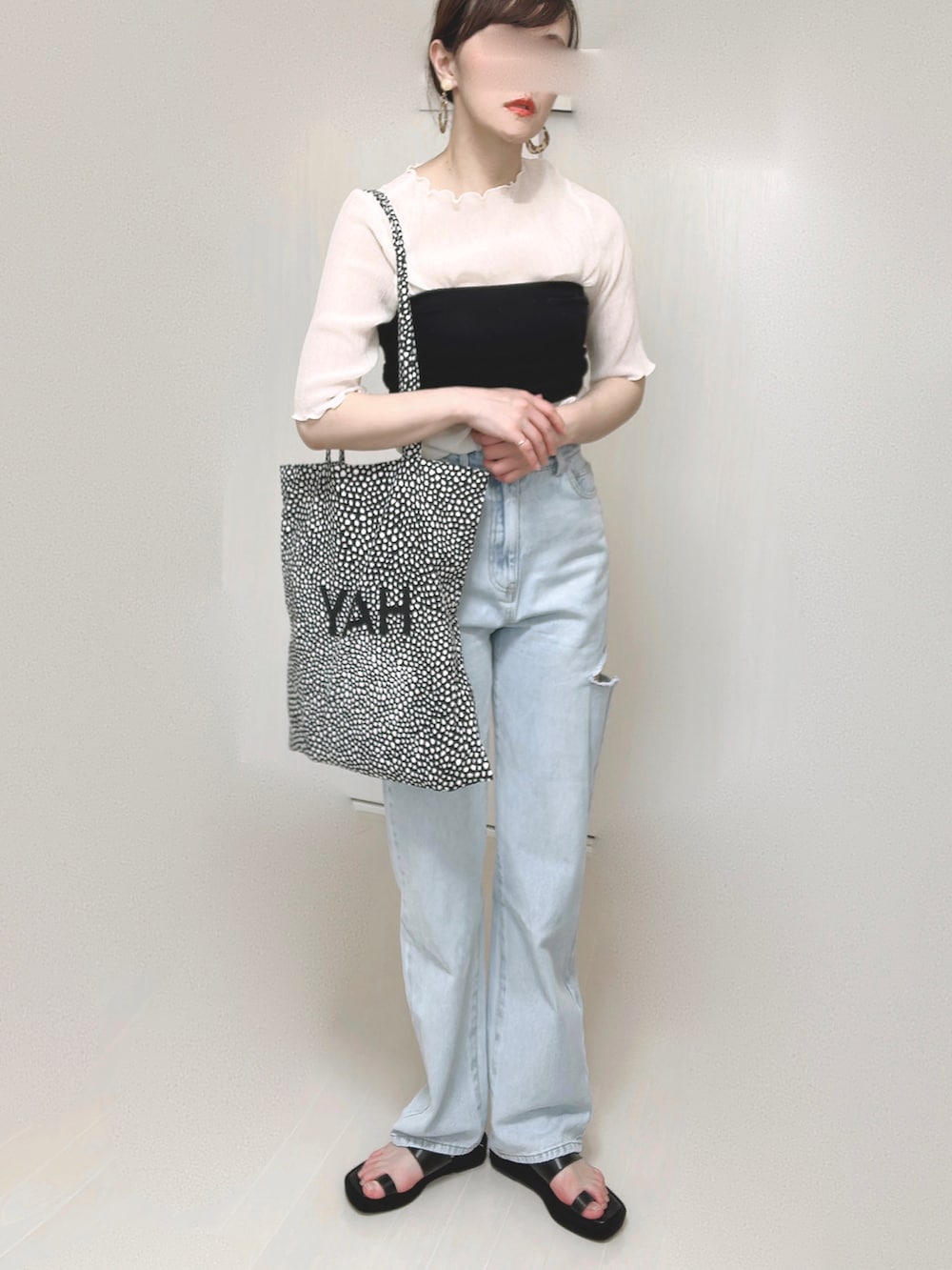 ブルー系のデニムパンツ、ベージュ系のTシャツ/カットソー、ブラック系のサンダルを着用したレディースの春コーディネートの3枚目の写真