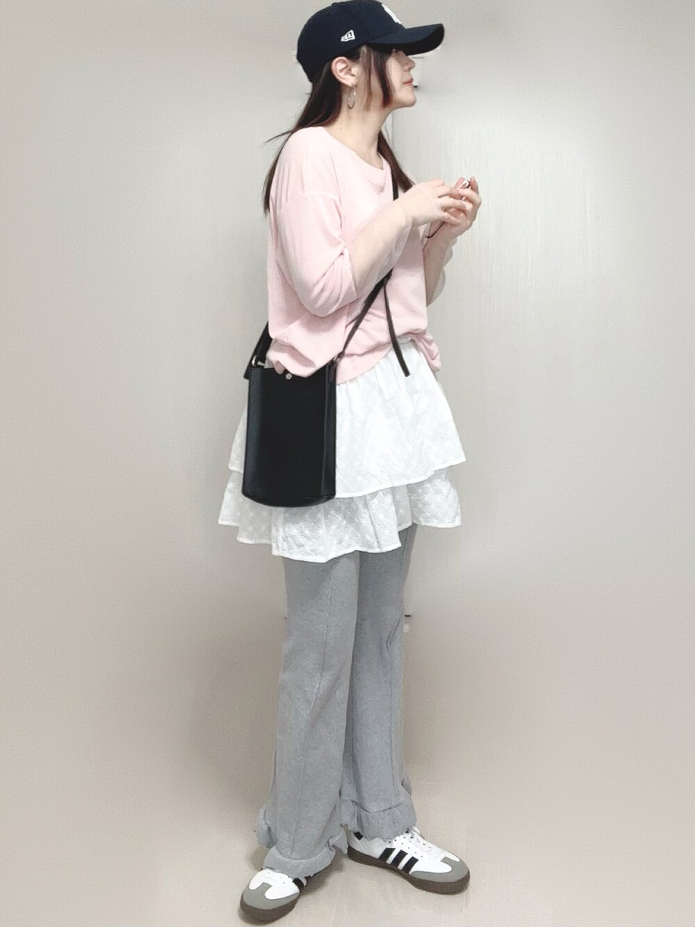 ホワイト系のスカート、ピンク系のTシャツ/カットソー、ブラック系のショルダーバッグを着用したレディースの春コーディネートの5枚目の写真
