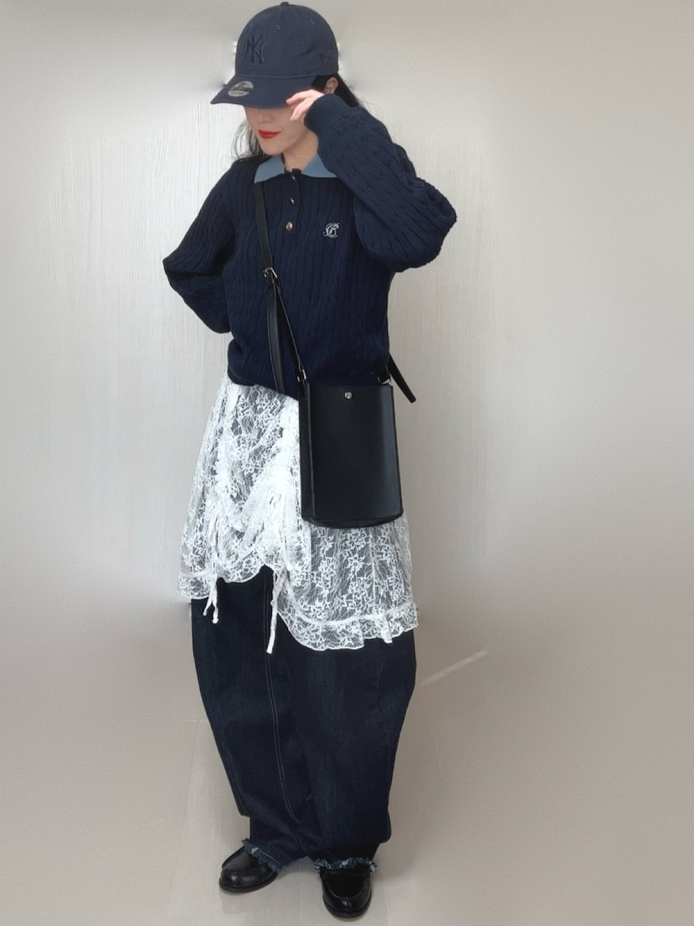 ブルー系のニット/セーター、ホワイト系のワンピース、ブラック系のデニムパンツを着用したレディースの冬コーディネートの3枚目の写真