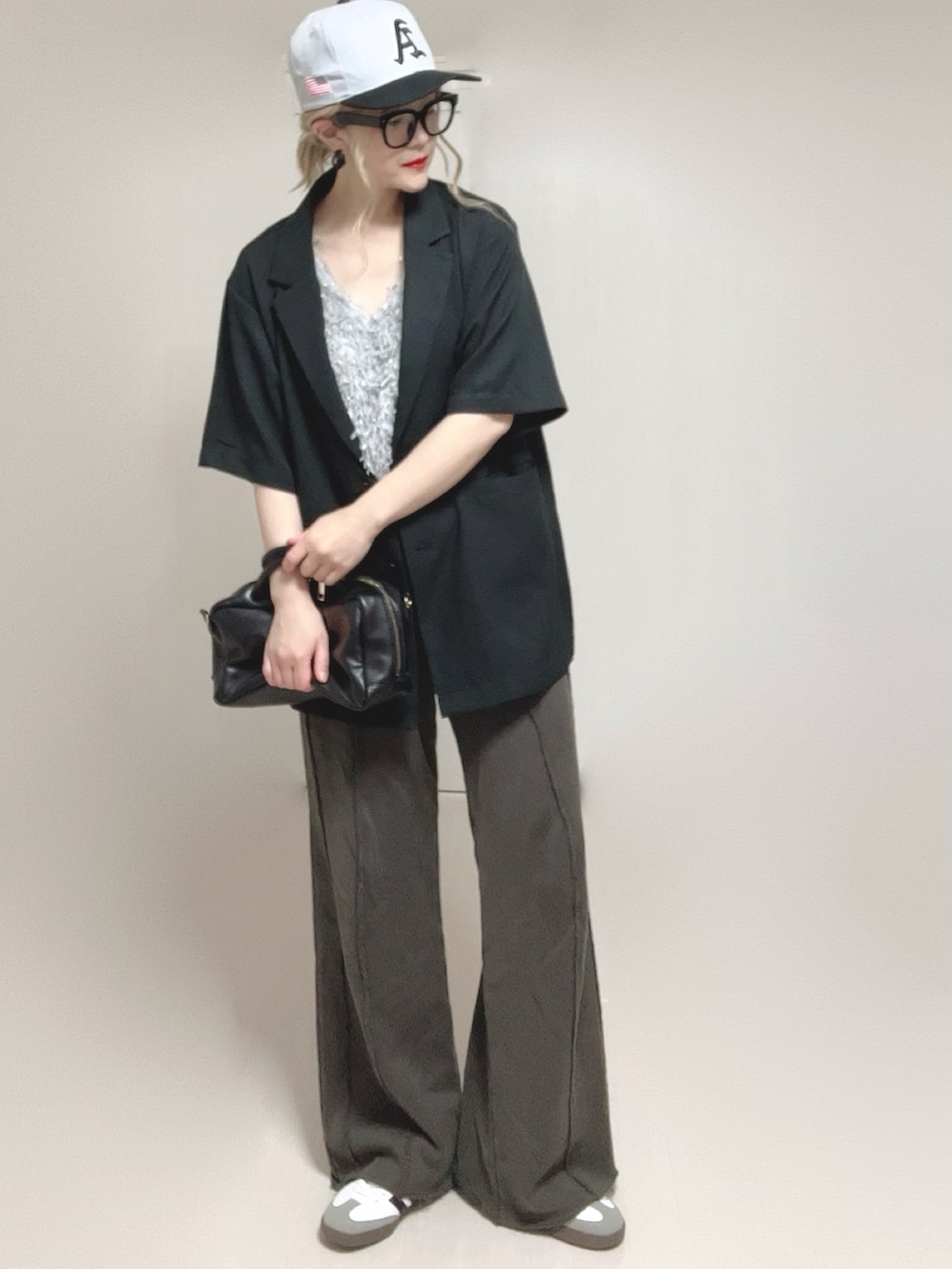 グレー系のベスト、ブラック系のテーラードジャケット、ブラック系のスウェットパンツを着用したレディースの夏コーディネートの2枚目の写真