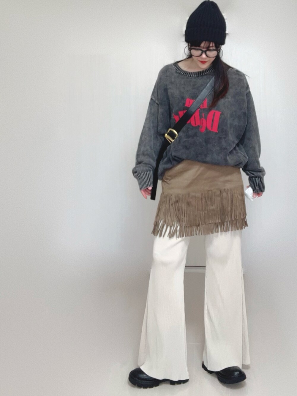 ブラック系のニット/セーター、ホワイト系のその他パンツ、ブラック系のブーツを着用したレディースの秋コーディネートの5枚目の写真