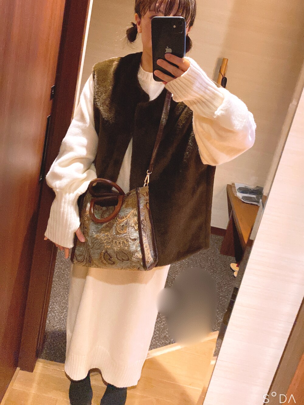 ホワイト系のワンピース、ブラウン系のベスト、グリーン系のショルダーバッグを着用したレディースの冬コーディネートの2枚目の写真