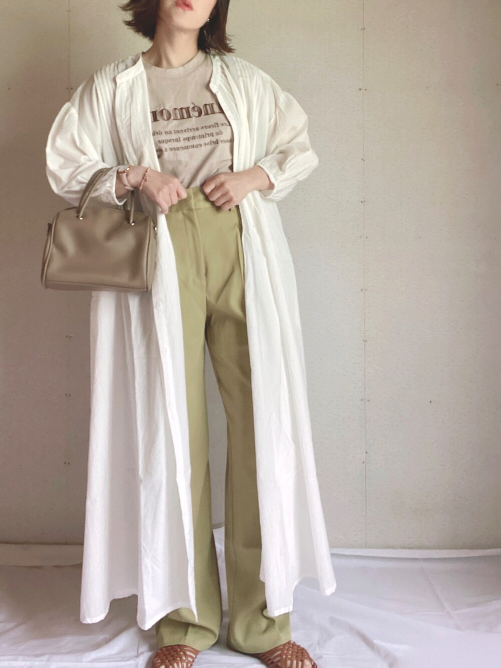 グリーン系のスラックス、ホワイト系のシャツワンピース、ブラウン系のサンダルを着用したレディースの夏コーディネートの4枚目の写真