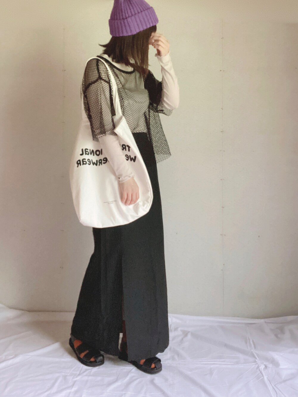 ブラック系のスカート、グレー系のTシャツ/カットソー、ホワイト系のトートバッグを着用したレディースの夏コーディネートの3枚目の写真