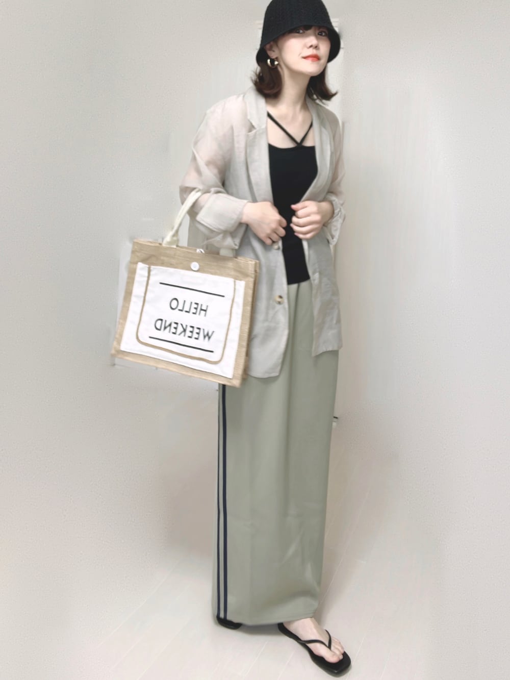 ブルー系のスカート、グレー系のテーラードジャケット、ブラック系のキャミソールを着用したレディースの夏コーディネートの4枚目の写真