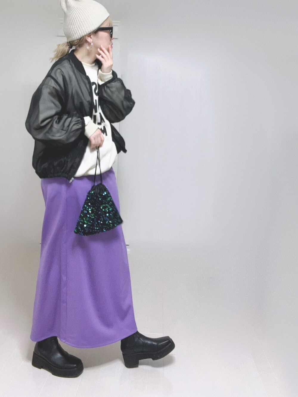 パープル系のスカート、ブラック系のブーツを着用したレディースの冬コーディネートの4枚目の写真