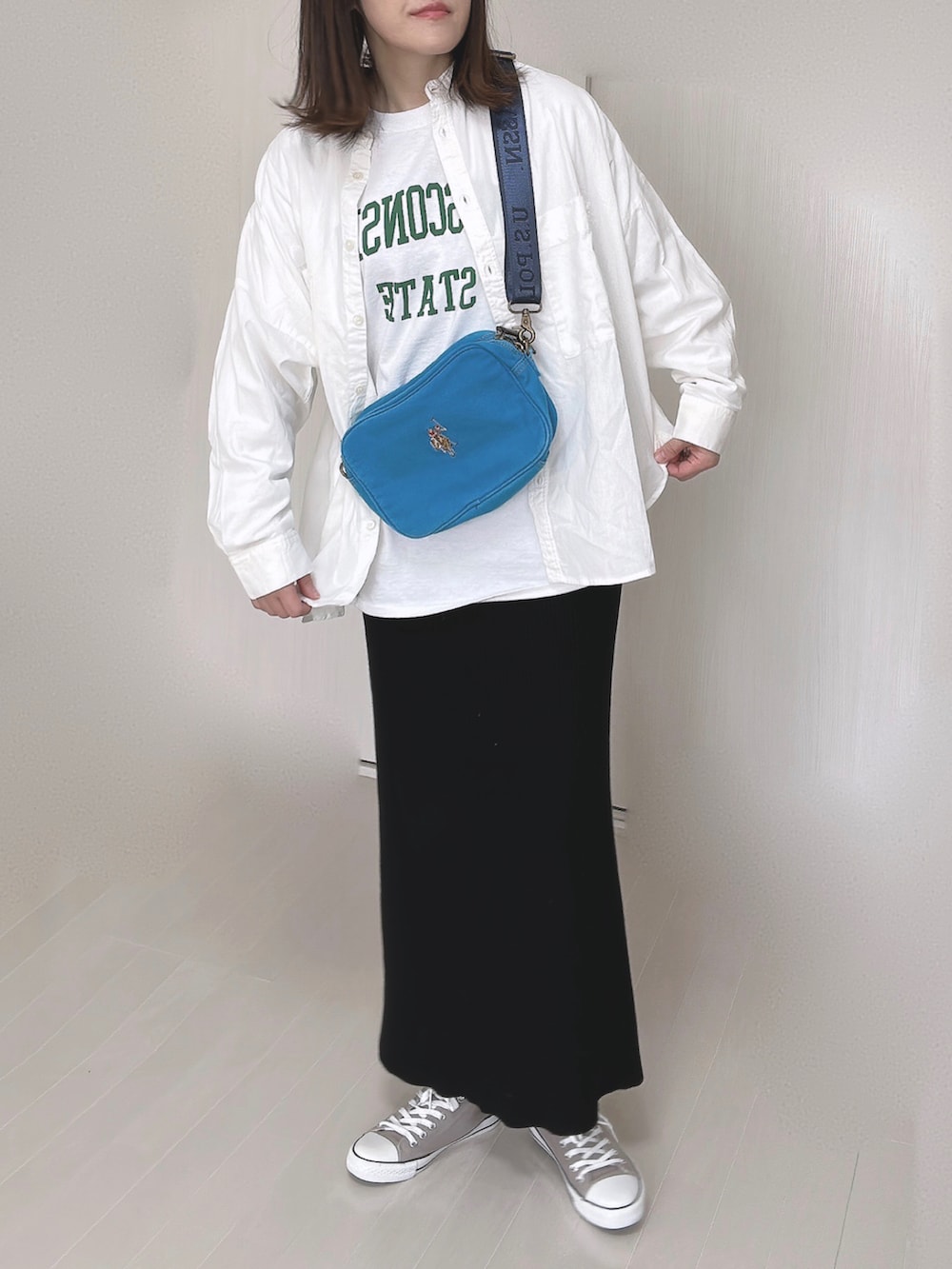 ブルー系のショルダーバッグ、ホワイト系のシャツ/ブラウス、ホワイト系のTシャツ/カットソーを着用したレディースの冬コーディネートの3枚目の写真