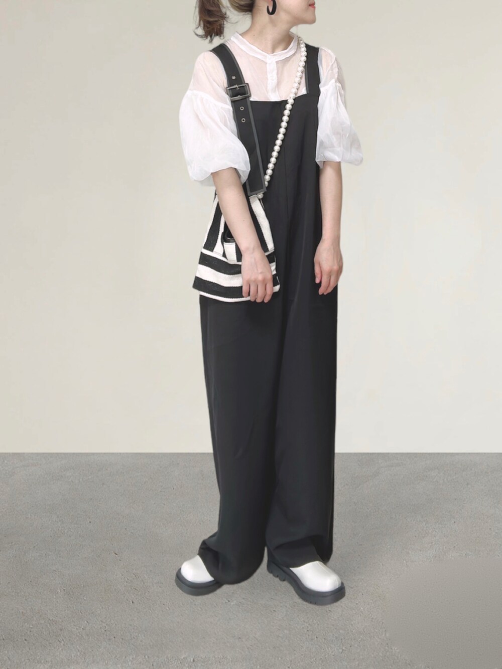 ブラック系のサロペット/オーバーオール、ホワイト系のシャツ/ブラウス、ホワイト系のショルダーバッグを着用したレディースの秋コーディネートの5枚目の写真