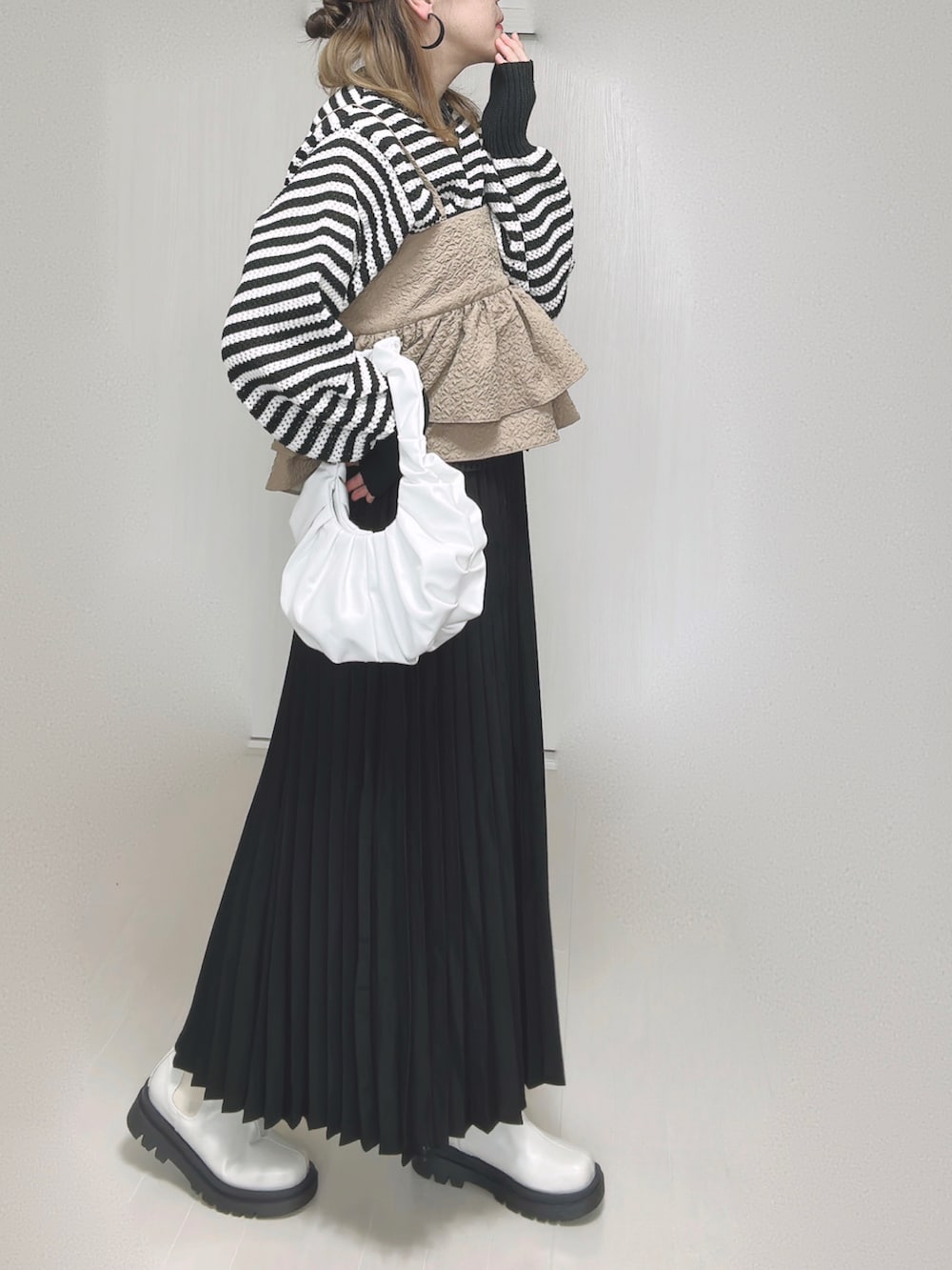 ホワイト系のカーディガン/ボレロ、ベージュ系のキャミソール、ブラック系のスカートを着用したレディースの秋コーディネートの2枚目の写真