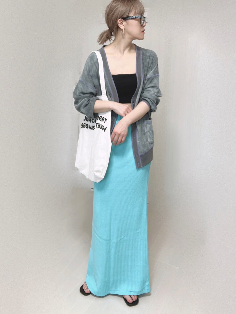 ブラック系のカーディガン/ボレロ、ホワイト系のトートバッグ、ブルー系のスカートを着用したレディースの春コーディネートの4枚目の写真