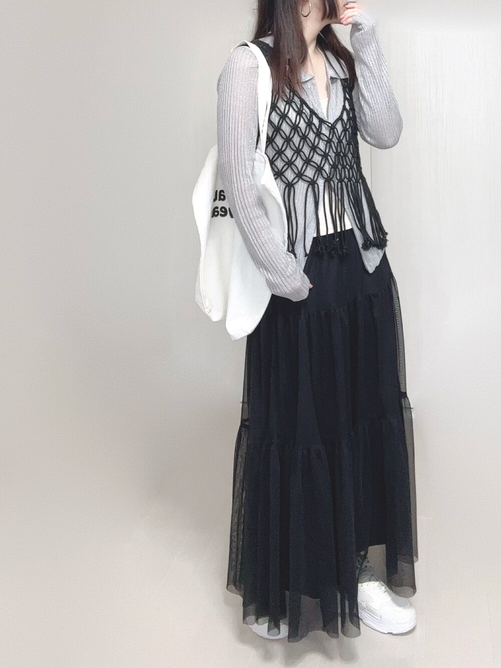 グレー系のカーディガン/ボレロ、ブラック系のスカート、ブラック系のベストを着用したレディースの春コーディネートの2枚目の写真