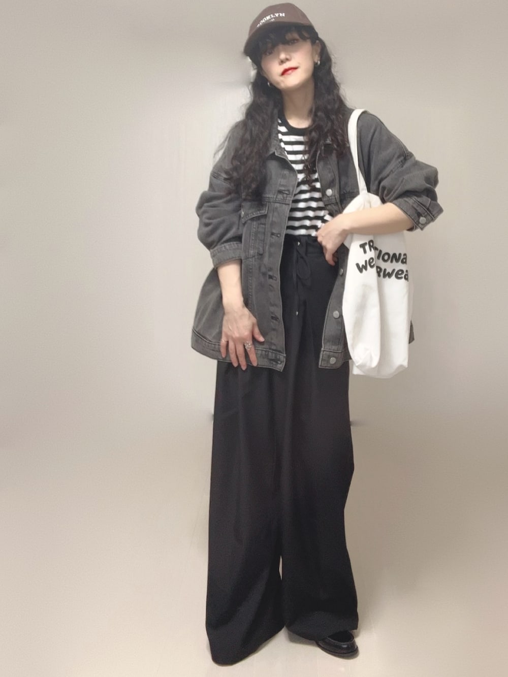 ブラック系のデニムジャケット、ブラック系のスラックス、ホワイト系のTシャツ/カットソーを着用したレディースの春コーディネートの2枚目の写真