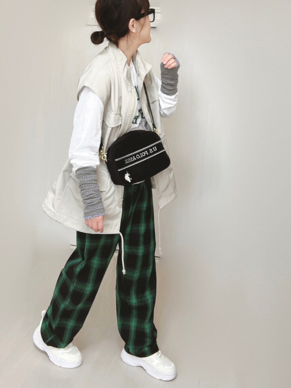 ホワイト系のTシャツ/カットソー、ホワイト系のベスト、ブラック系のショルダーバッグを着用したレディースの春コーディネートの3枚目の写真