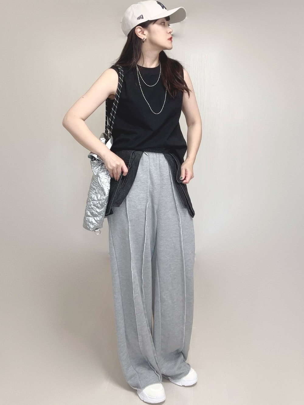 グレー系のスウェットパンツ、シルバー系のトートバッグ、ホワイト系のスニーカーを着用したレディースの夏コーディネートの5枚目の写真