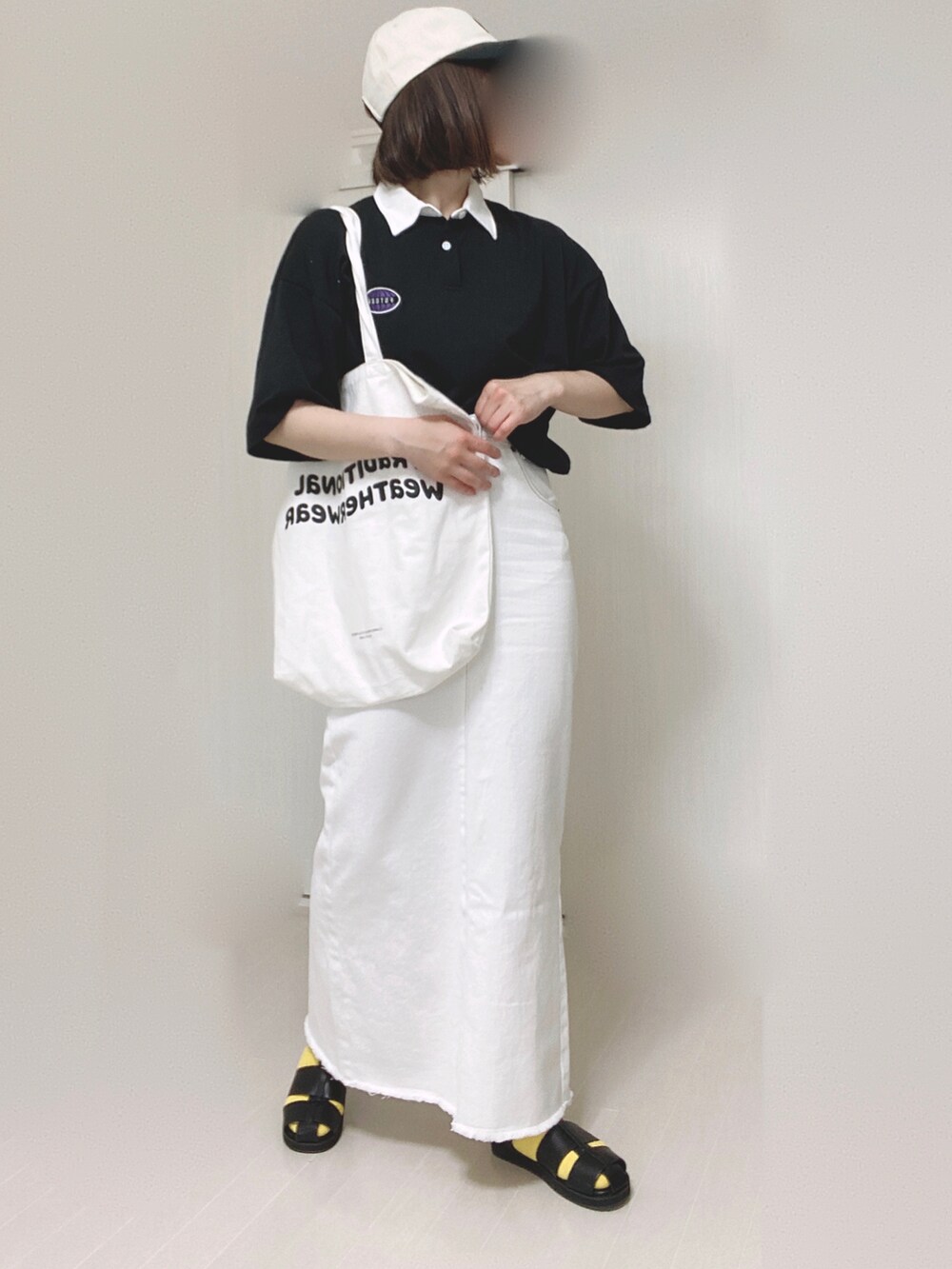 ベージュ系のデニムスカート、ホワイト系のトートバッグ、ブラック系のサンダルを着用したレディースの夏コーディネートの4枚目の写真