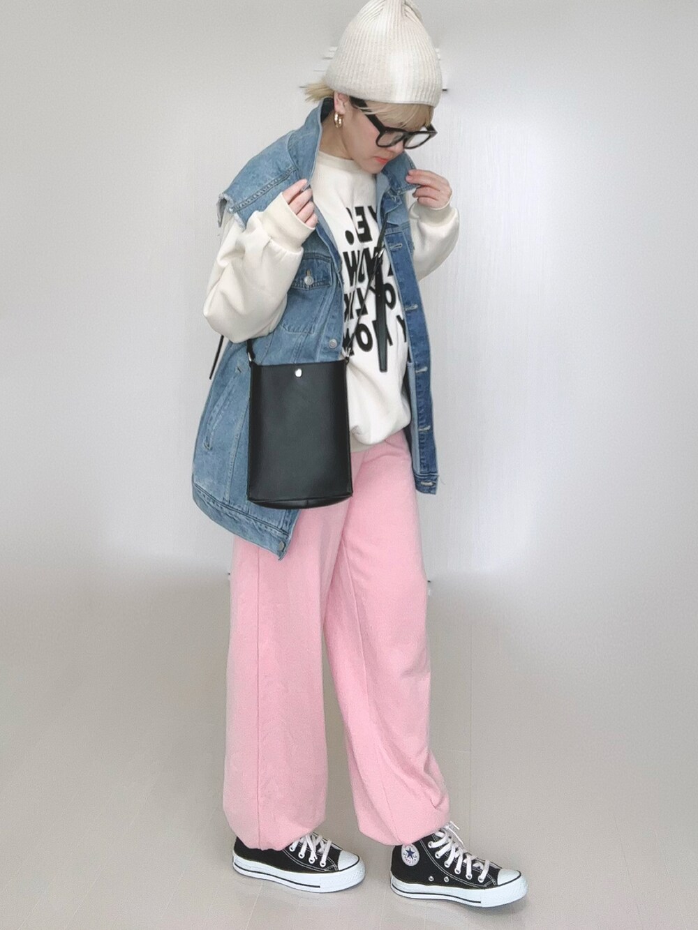 ブルー系のベスト、ブラック系のショルダーバッグ、ピンク系のスウェットパンツを着用したレディースの冬コーディネートの3枚目の写真