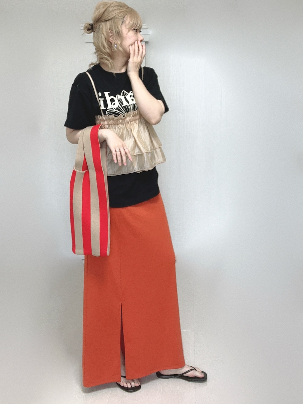 オレンジ系のキャミソール、ブラック系のTシャツ/カットソー、オレンジ系のスカートを着用したレディースの夏コーディネートの2枚目の写真