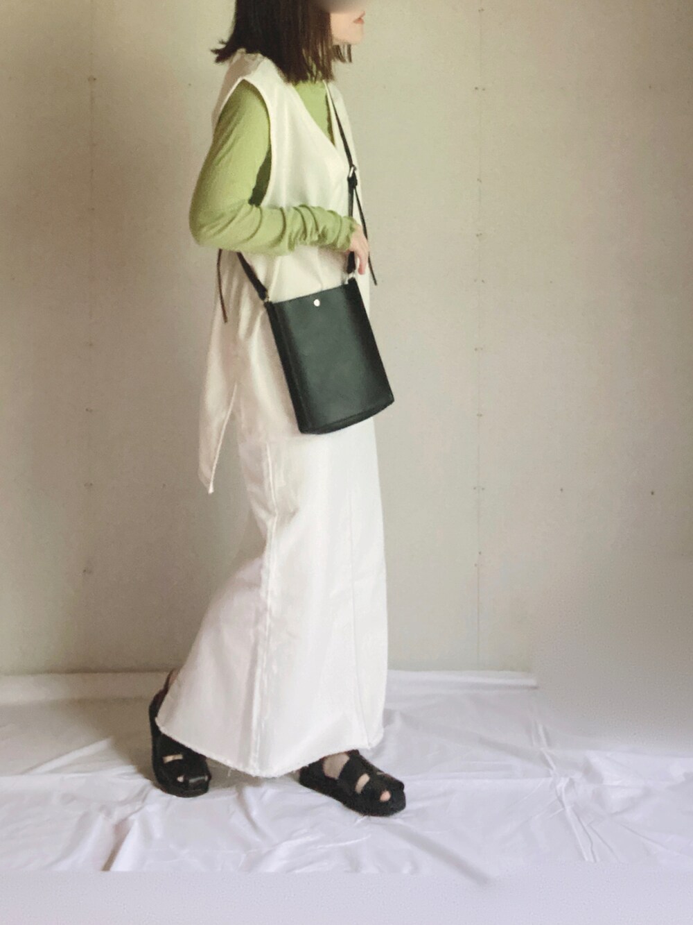 ベージュ系のデニムスカート、グリーン系のTシャツ/カットソー、ブラック系のショルダーバッグを着用したレディースの夏コーディネートの3枚目の写真