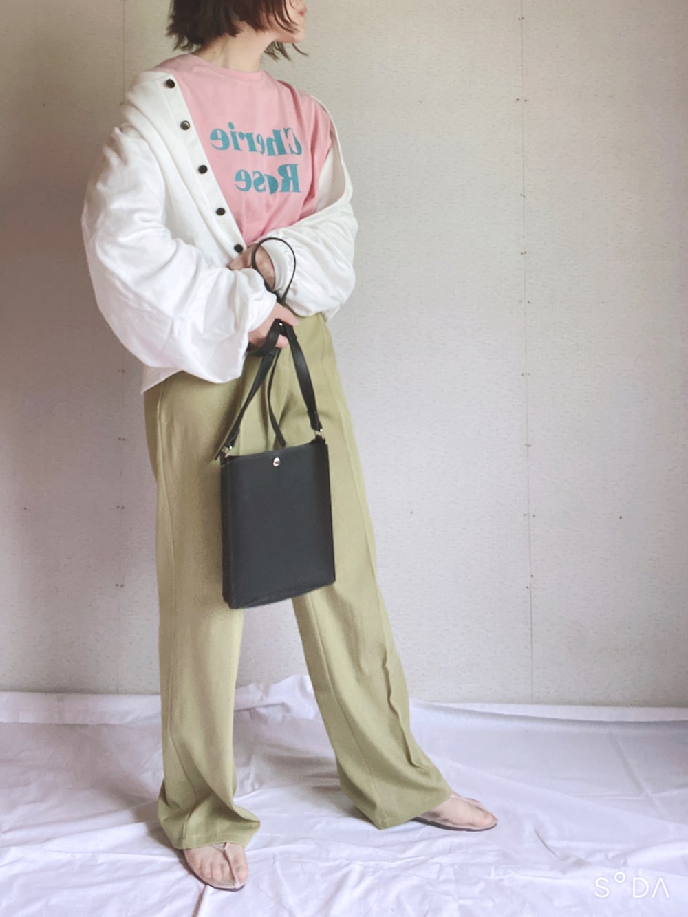 ブラック系のカーディガン/ボレロ、ピンク系のTシャツ/カットソー、グリーン系のスラックスを着用したレディースの夏コーディネートの2枚目の写真