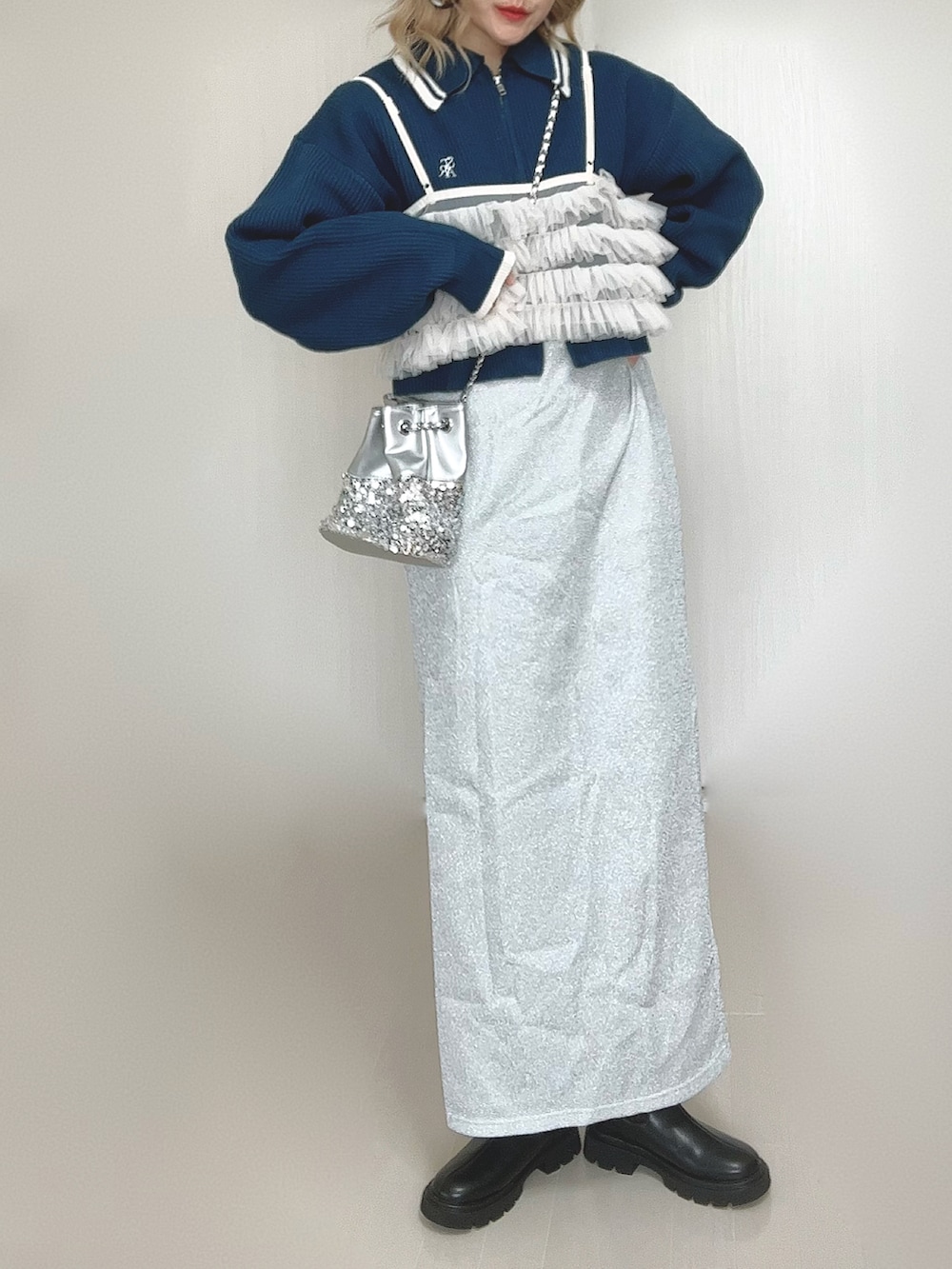 ブルー系のニット/セーター、ブラック系のブーツ、シルバー系のショルダーバッグを着用したレディースの秋コーディネートの3枚目の写真