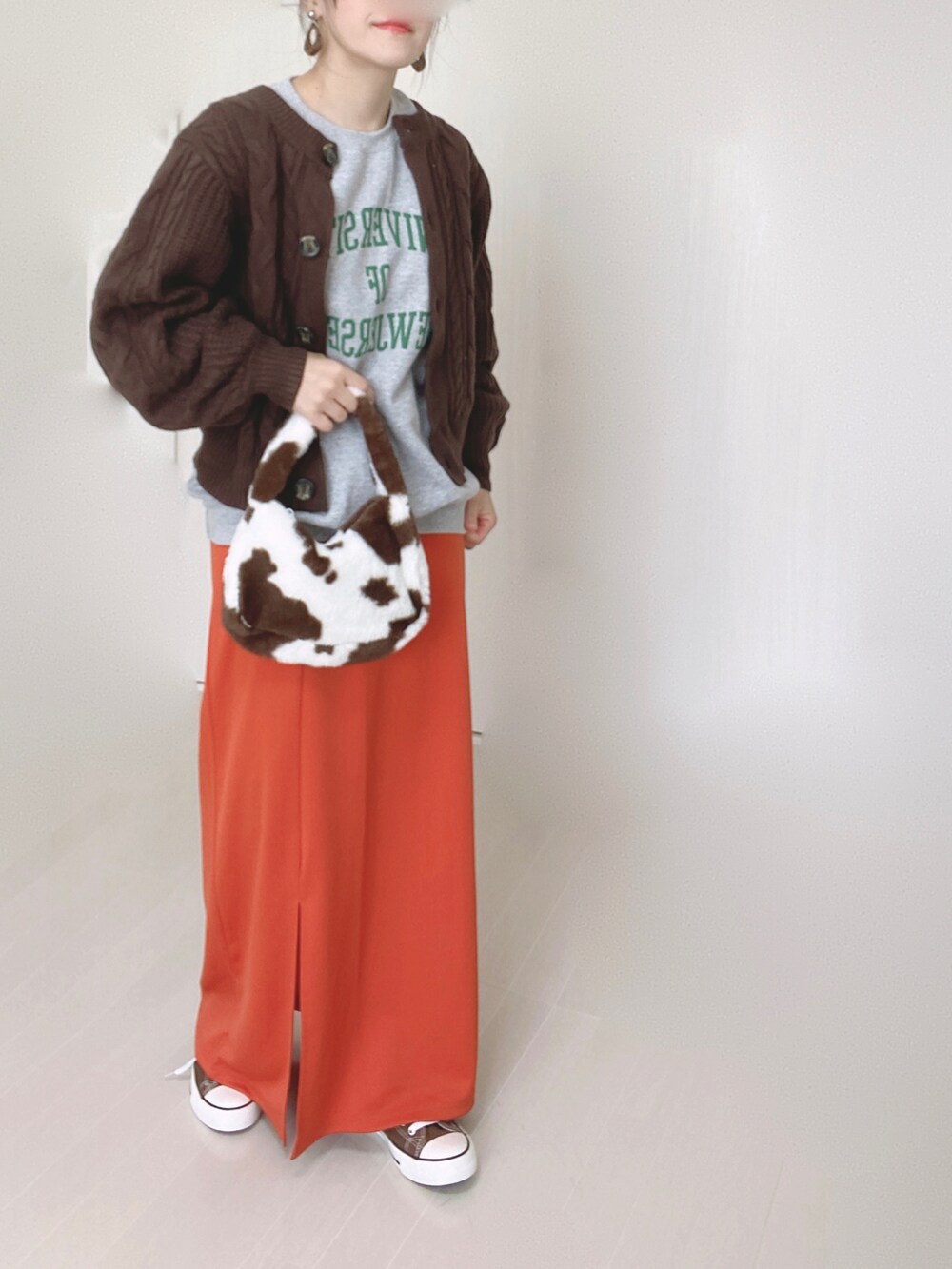 グレー系のスウェット、オレンジ系のスカート、ブラウン系のニット/セーターを着用したレディースの秋コーディネートの4枚目の写真