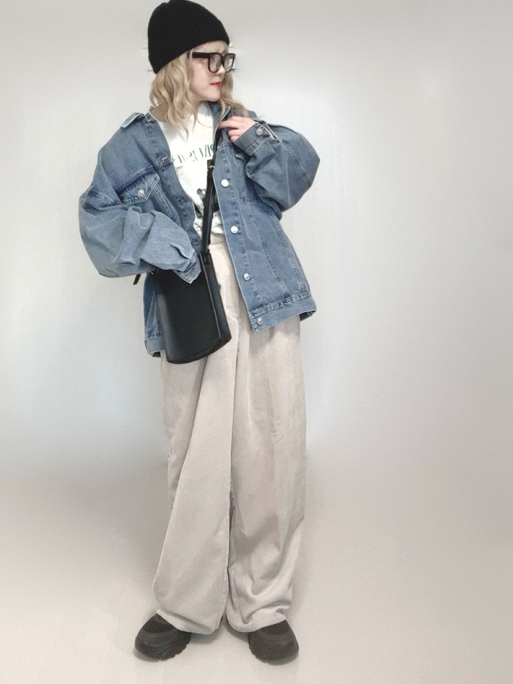 ブルー系のデニムジャケット、ホワイト系のTシャツ/カットソー、ブラック系のショルダーバッグを着用したレディースの春コーディネートの3枚目の写真