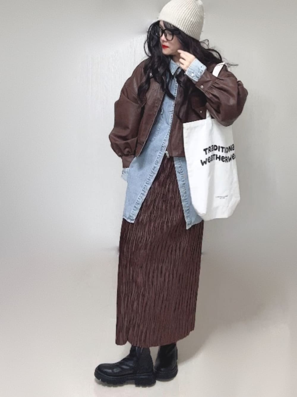 ブルー系のシャツ/ブラウス、ブラウン系のブルゾン、ブラック系のブーツを着用したレディースの冬コーディネートの3枚目の写真