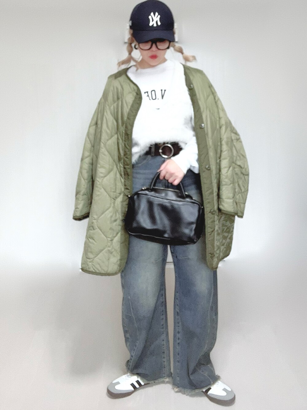 ホワイト系のベスト、ホワイト系のTシャツ/カットソー、グリーン系のミリタリージャケットを着用したレディースの秋コーディネートの3枚目の写真