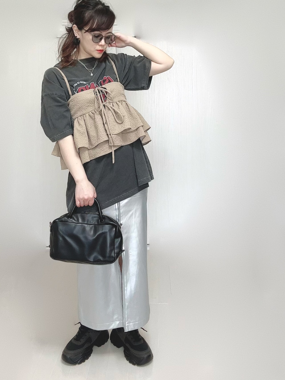 グレー系のTシャツ/カットソー、ベージュ系のキャミソール、シルバー系のスカートを着用したレディースの春コーディネートの2枚目の写真