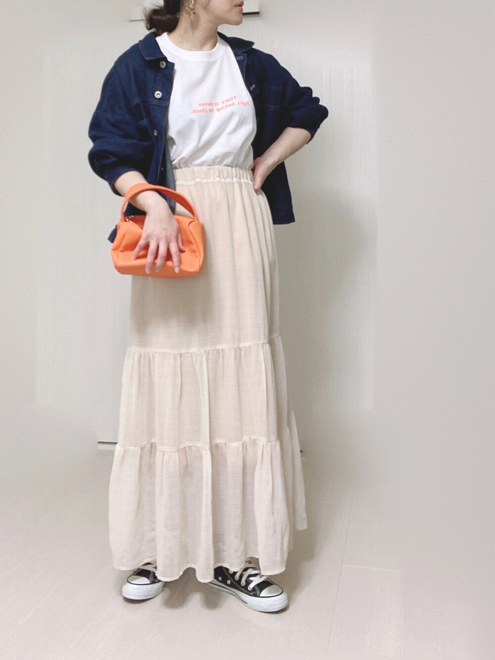 オレンジ系のTシャツ/カットソー、ブルー系のデニムジャケット、オレンジ系のショルダーバッグを着用したレディースの春コーディネートの4枚目の写真