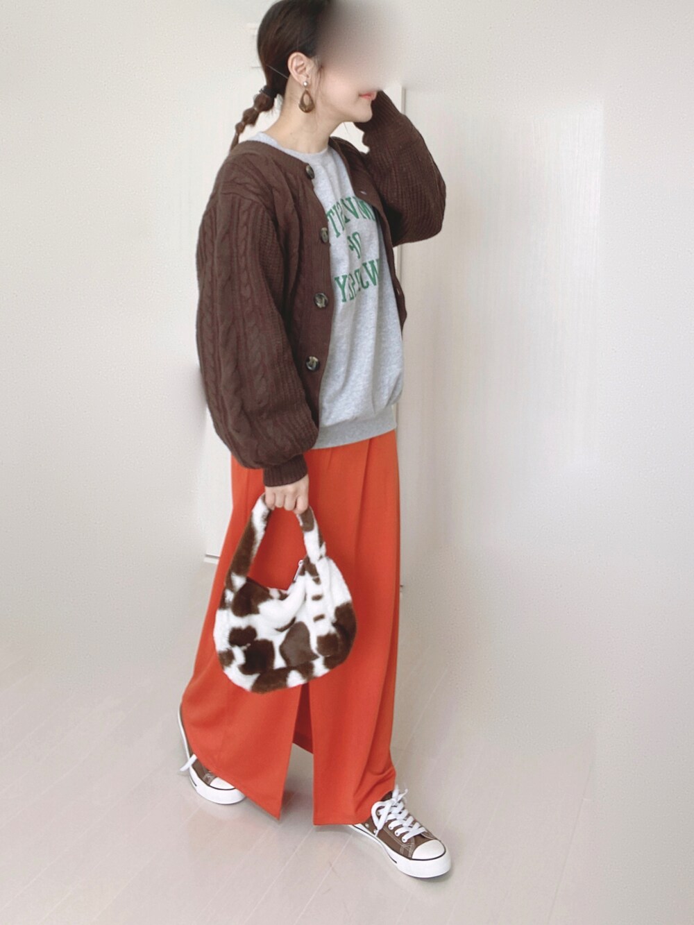 グレー系のスウェット、オレンジ系のスカート、ブラウン系のニット/セーターを着用したレディースの秋コーディネートの3枚目の写真