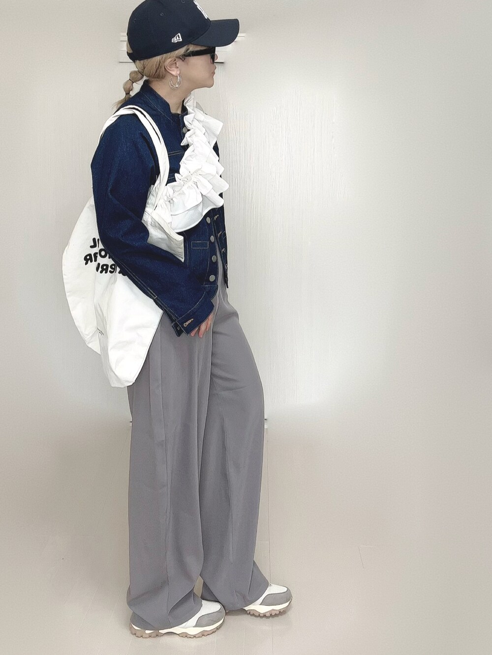 ブルー系のデニムジャケット、グレー系のその他パンツ、ホワイト系のトートバッグを着用したレディースの春コーディネートの2枚目の写真