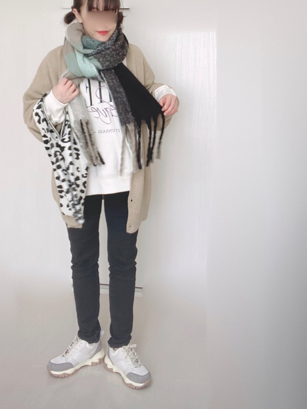 ベージュ系のカーディガン/ボレロ、ブラック系のデニムパンツ、ベージュ系のスニーカーを着用したレディースの冬コーディネートの2枚目の写真