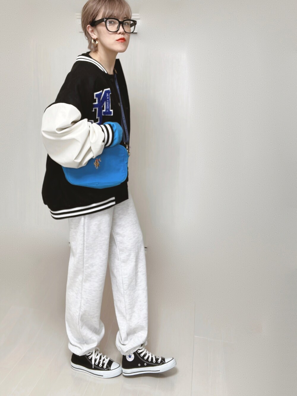 ブルー系のショルダーバッグ、ブラック系のスタジャン、ブラック系のカーディガン/ボレロを着用したレディースの春コーディネートの4枚目の写真