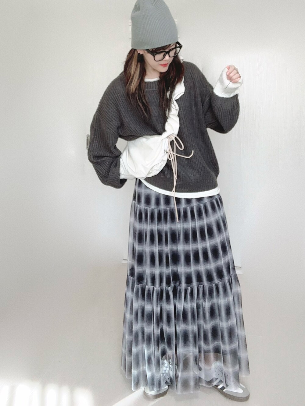 グレー系のニット/セーター、ホワイト系のショルダーバッグ、ブラック系のスカートを着用したレディースの秋コーディネートの4枚目の写真