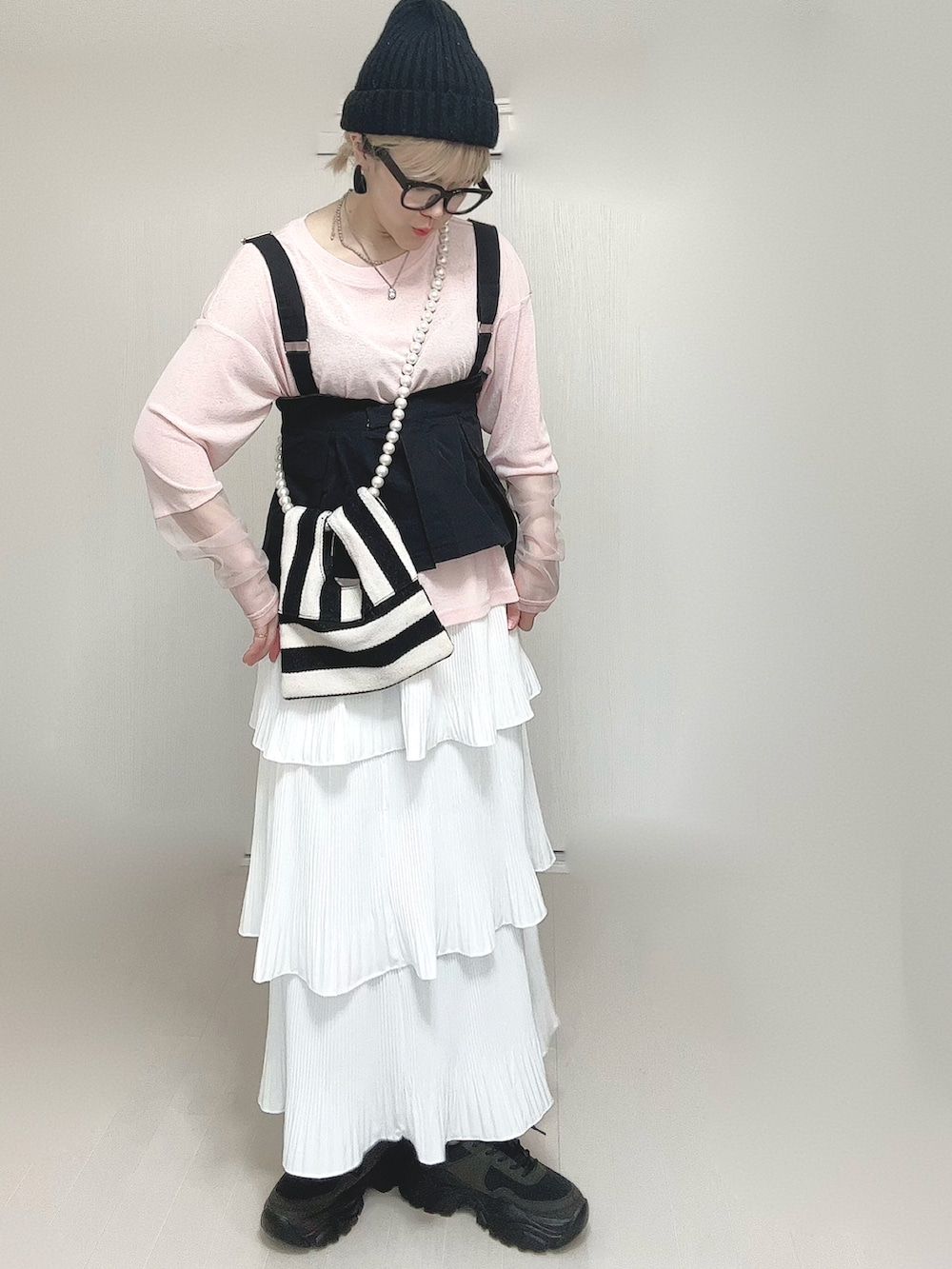 ピンク系のTシャツ/カットソー、ブラック系のベスト、ホワイト系のショルダーバッグを着用したレディースの春コーディネートの2枚目の写真