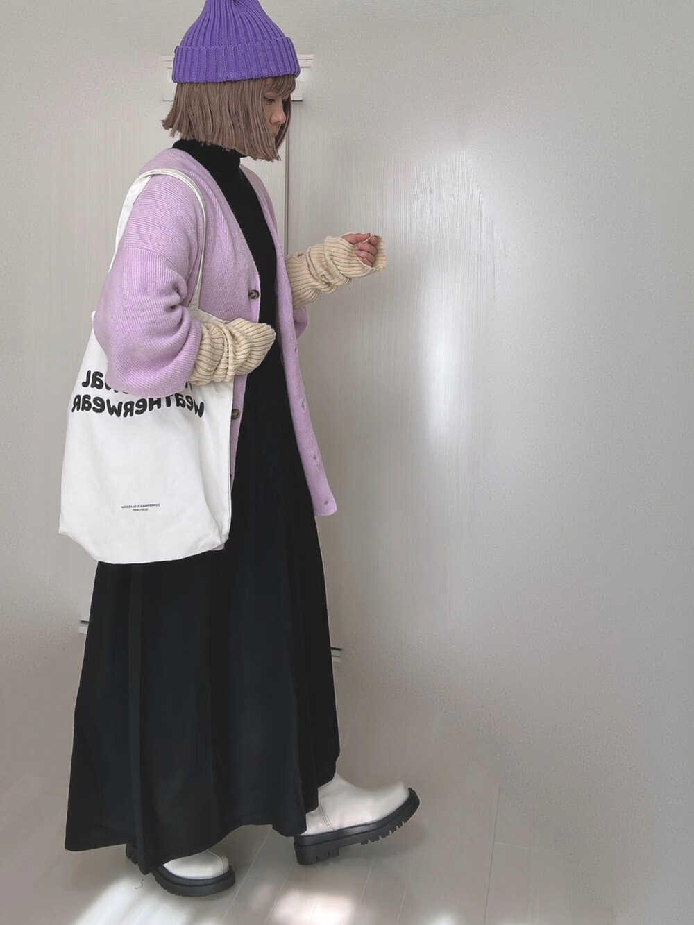 パープル系のカーディガン/ボレロ、ホワイト系のトートバッグ、ブラック系のシャツワンピースを着用したレディースの冬コーディネートの5枚目の写真