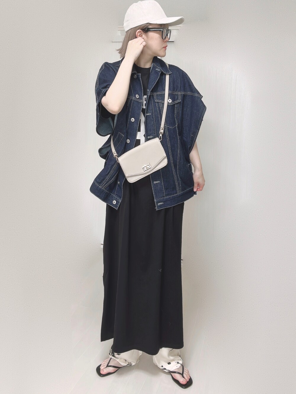 ブルー系のベスト、ベージュ系のショルダーバッグ、ブラック系のサンダルを着用したレディースの春コーディネートの3枚目の写真