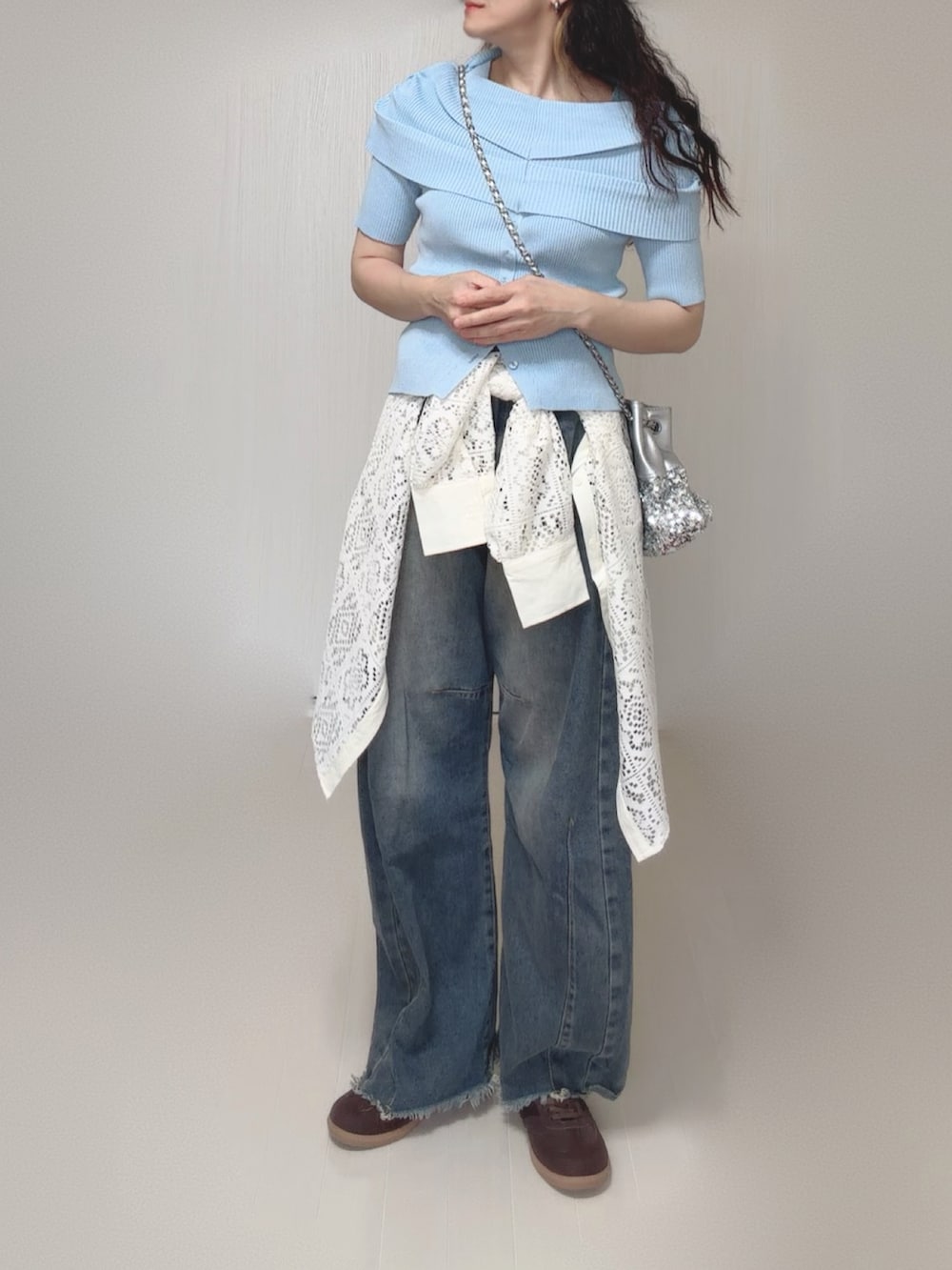 ブルー系のニット/セーター、ホワイト系のシャツ/ブラウス、シルバー系のショルダーバッグを着用したレディースの夏コーディネートの2枚目の写真
