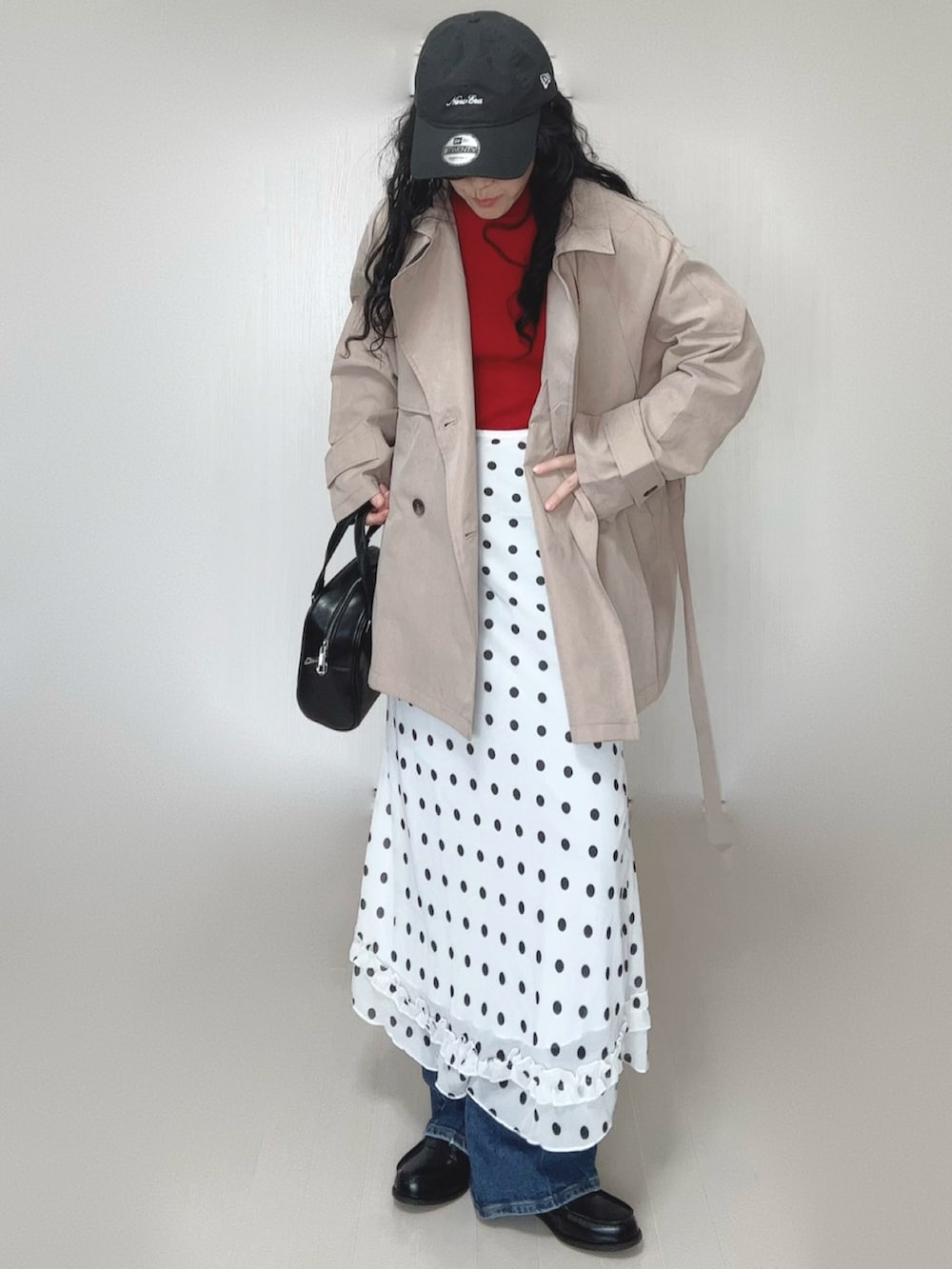 レッド系のニット/セーター、ベージュ系のトレンチコート、ブラック系のボストンバッグを着用したレディースの春コーディネートの4枚目の写真
