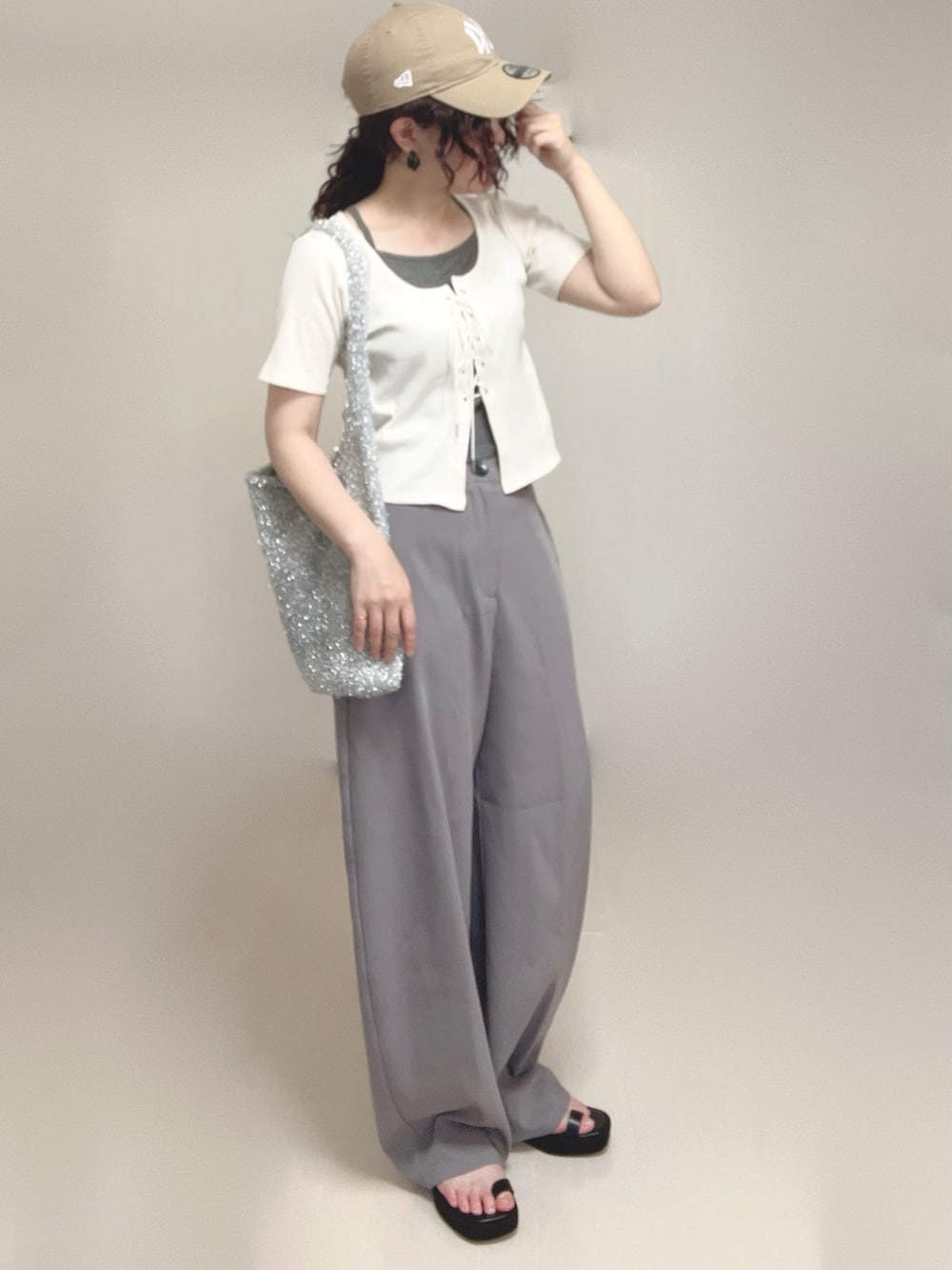 グレー系のその他パンツ、ブラック系のサンダル、ホワイト系のTシャツ/カットソーを着用したレディースの夏コーディネートの2枚目の写真
