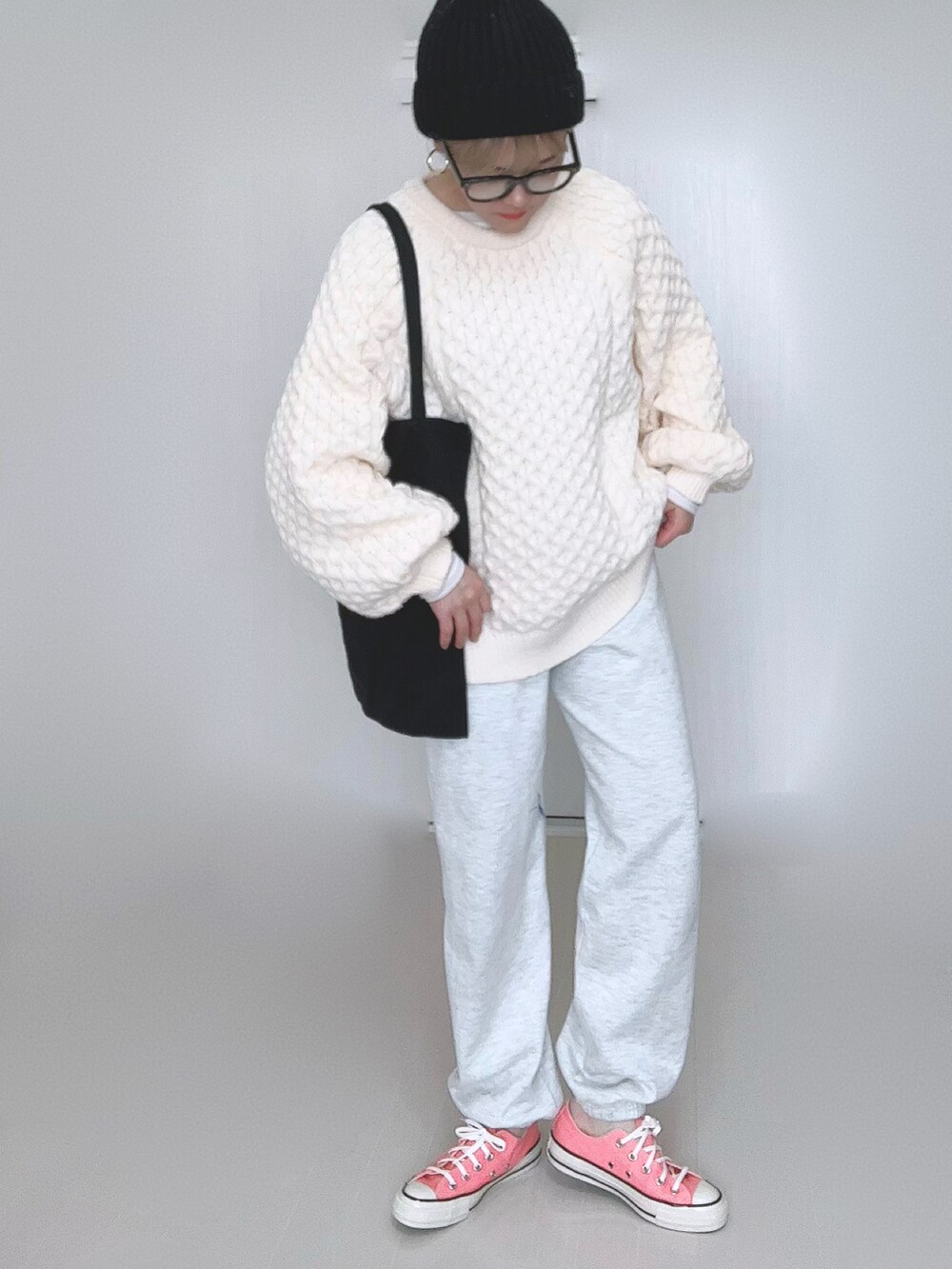 ホワイト系のニット/セーター、ブラック系のトートバッグ、ピンク系のスニーカーを着用したレディースの冬コーディネートの3枚目の写真