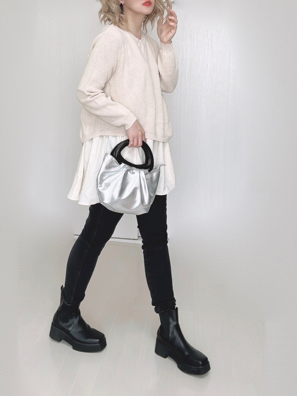 ベージュ系のニット/セーター、ブラック系のデニムパンツを着用したレディースの秋コーディネートの3枚目の写真